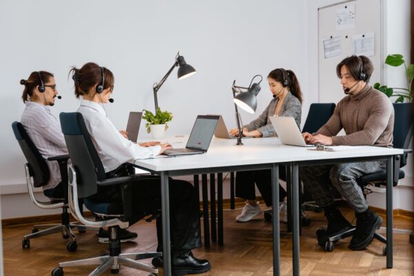 Team of diverse call center agents working diligently in a modern office setting.