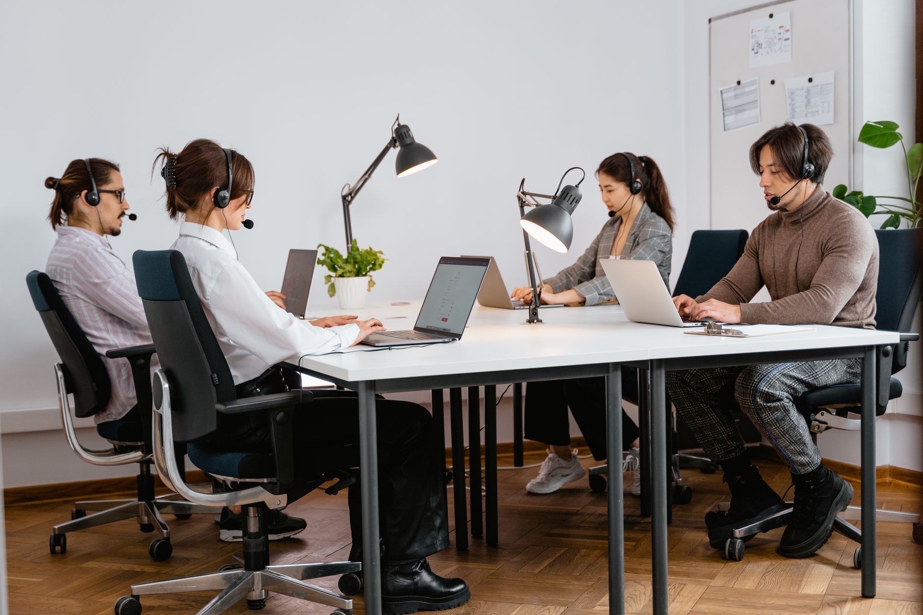 Team of diverse call center agents working diligently in a modern office setting.